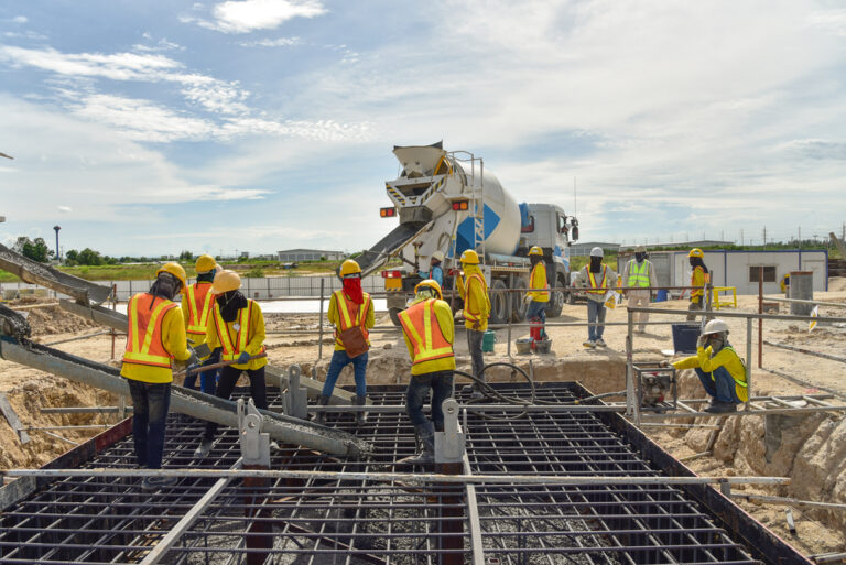 Workers pouring a concrete for a concrete slab
