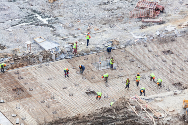 Workers setting up a slab to be poured by a concrete for a commercial building
